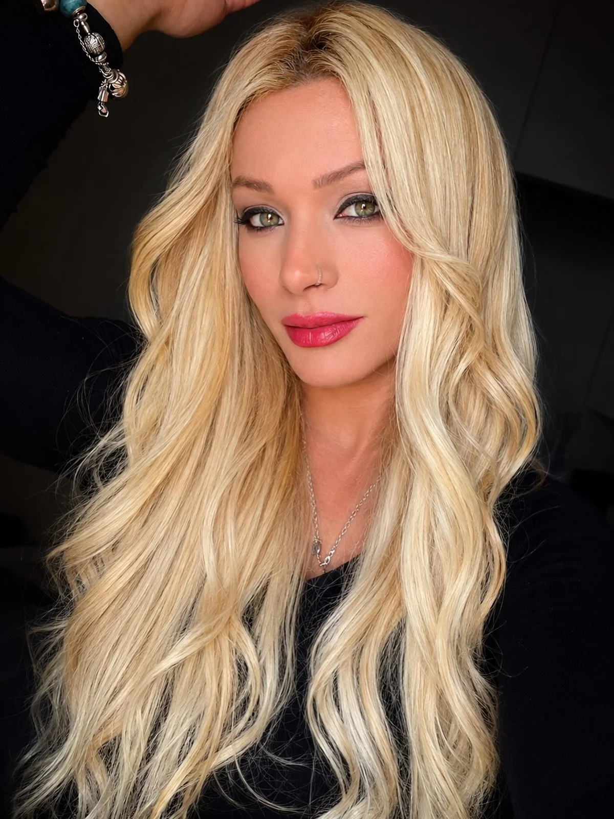 Retrato de Evelyn Soares com cabelo loiro longo e batom vermelho